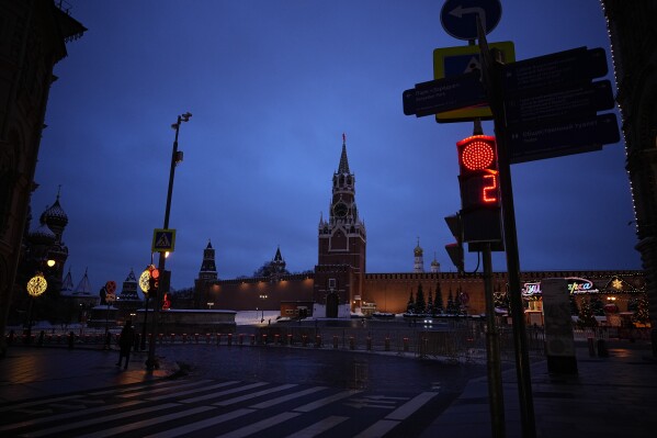 A traffic light shows a red light with an almost empty Red Square, Kremlin Wall and the Spasskaya Tower in the background at dawn in Moscow, Russia, Tuesday, Jan. 30, 2024. (AP Photo/Alexander Zemlianichenko)
