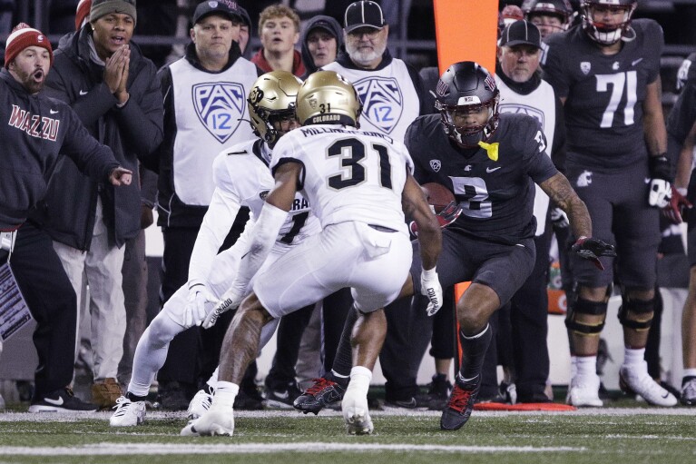 Washington State wide receiver Josh Kelly (3) carries the ball as Colorado safety Jaden Milliner Jones (31) and cornerback Cormani McClain (1) pressure him during the first half of an NCAA college football game Friday, Nov. 17, 2023, in Pullman, Wash. (AP Photo/Young Kwak)