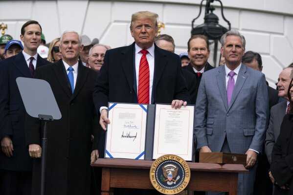 President Donald Trump shows off a new North American trade agreement with Canada and Mexico, during an event at the White House, Wednesday, Jan. 29, 2020, in Washington. The president is joined by, from left, senior advisers Jared Kushner and  Ivanka Trump, Vice President Mike Pence, House Minority Whip Steve Scalise, R-La., U.S. Trade Representative Robert Lighthizer, House Minority Leader Kevin McCarthy of Calif., and others.(AP Photo/ Evan Vucci)