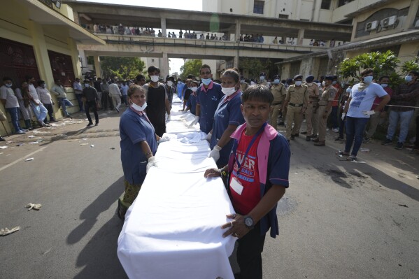Trabajadores del Hospital Civil esperan recibir los restos de las víctimas del avión que se estrelló en la ciudad de Ahmedabad, en el noroeste de India, en el estado de Gujarat, el jueves 12 de junio de 2025. (Foto AP/Ajit Solanki)