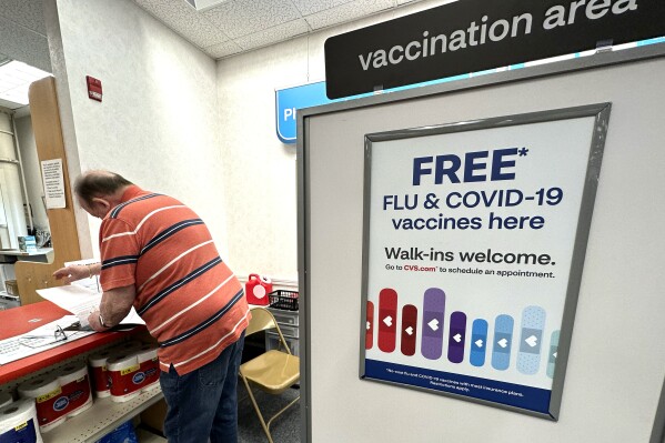 FILE - A sign for flu and covid vaccinations is displayed at a pharmacy store in Palatine, Ill., Wednesday, Sept. 13, 2023. The flu is hanging on in the U.S., intensifying in some areas of the country after weeks of apparent decline., according to data released by the U.S. Centers for Disease Control and Prevention on Friday, Feb. 9, 2024. (AP Photo/Nam Y. Huh, File)