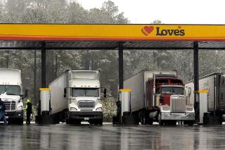FILE - In this Feb. 11, 2014, file photo, truck drivers stop at a gas station in Emerson, Ga., north of metro Atlanta, to fill up their tractor trailer rigs. The Biden administration is proposing stronger pollution regulations for new tractor-trailer rigs that would clean up smoky diesel engines and encourage new technologies during the next two decades. The proposal released Monday by the Environmental Protection Agency would require the industry to cut smog-and-soot-forming nitrogen oxide emissions by up to 90% per truck over current standards by 2031. (AP Photo/David Tulis, File)