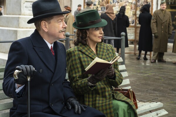 This image released by 20th Century Studios shows Kenneth Branagh as Hercule Poirot, left, and and Tina Fey as Ariadne Oliver in a scene from "A Haunting in Venice." (20th Century Studios via AP)