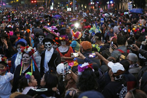 People dressed as Catrinas parade down Mexico City's iconic Reforma avenue during celebrations for the Day of the Dead in Mexico, City, Saturday, Oct. 26, 2019. (AP Photo/Ginnette Riquelme)