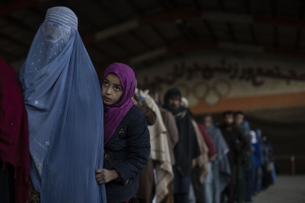 FILE - Women queue to receive cash at a money distribution site organized by the World Food Program in Kabul, Afghanistan, on Nov. 20, 2021. The U.N. food agency said Tuesday, Sept.. 5, 2023, it must drop another 2 million hungry people from food assistance in Afghanistan this month due to a massive funding shortfall. The action means that 10 million people will be cut off from the agency's support this year in the country, the World Food Programme said in a statement. (AP Photo/Petros Giannakouris)