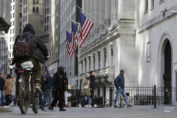 People pass the front of the New York Stock Exchange in New York, Tuesday, March 21, 2023. (AP Photo/Peter Morgan