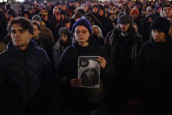 A woman holds a portrait of Lizaveta, a 25-year-old Belarusian woman who died after a being brutally attacked and raped on the streets of Warsaw last month, in Warsaw Poland, Wednesday, March 6, 2024.The crime has shocked people across Poland. Poles, Belarusians and Ukrainians gathered at the site of the crime in downtown Warsaw, placing flowers and lighting candles in honor of the woman known only as Lizaveta, or Liza. (AP Photo/Michal Dyjuk)