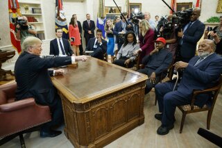 
              President Donald Trump meets with rapper Kanye West and former football player Jim Brown in the Oval Office of the White House, Thursday, Oct. 11, 2018, in Washington. (AP Photo/Evan Vucci)
            