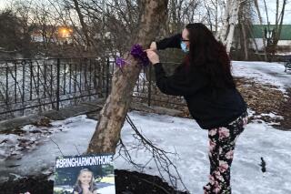 Crystal Sorey, the mother of five-year-old Harmony Montgomery who disappeared in 2019, pins a ribbon to a tree during a vigil for her daughter Feb. 12, 2022, at Bass Island Park, in Manchester, N.H. Months before the girl disappeared, a child protective services worker visited her home and concluded that an allegation that the girl received a black eye was unfounded, according to a review released Friday Feb. 25, 2022 through Gov. Chris Sununu's office. (AP Photo/Kathy McCormack)