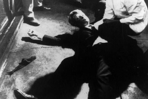 FILE - Hotel busboy Juan Romero, right, comes to the aid of Sen. Robert F. Kennedy, as he lies on the floor of the Ambassador Hotel in Los Angeles on June 5, 1968, moments after he was shot. Paul Schrade, a labor union leader who was shot in the head during the assassination of Kennedy and spent decades convinced that Sirhan Sirhan wasn't the killer, died Wednesday, Nov. 9, 2022, of natural causes. He was 97. (Boris Yaro/Los Angeles Times via AP, file)