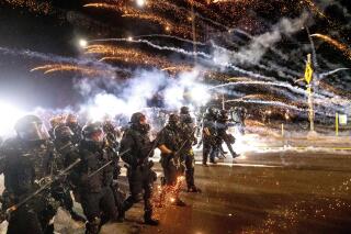 FILE - In this Sept. 5, 2020, file photo, police use chemical irritants and crowd control munitions to disperse protesters during a demonstration in Portland, Ore. Authorities said Tuesday, June 15, 2021, a grand jury returned an indictment against a Portland police officer, accusing him of hitting a protester in the head with a baton in 2020. The city saw widespread, often violent protests following the police killing of George Floyd. (AP Photo/Noah Berger, File)