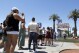 2024年6月6日，星期四，在拉斯维加斯，墨西哥的索菲亚·拉米雷斯（左）排队等待拍照，在“欢迎来到神奇的拉斯维加斯”标志牌上喝水。（史蒂夫·马库斯/拉斯维加斯太阳报通过美联社）