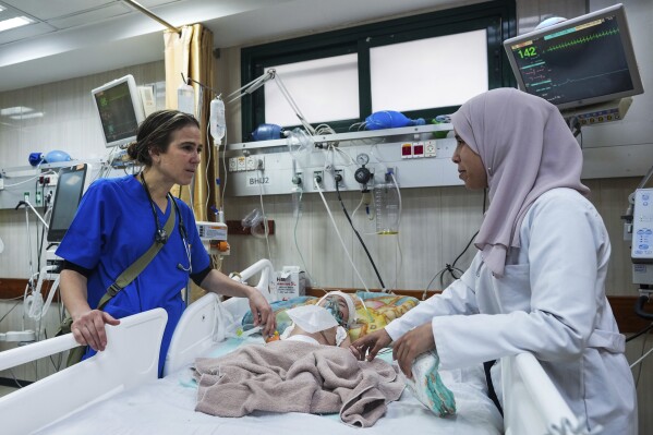 Pediatrician Tanya Haj-Hassan, left, examines wounded children at Al-Aqsa Martyrs Hospital in Deir al-Balah, central Gaza. Saturday, March 16, 2024. (AP Photo/Abdel Kareem Hana)