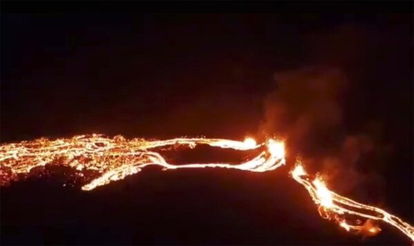 This photo provided by the Icelandic Met Office shows an eruption, center right, on the Reykjanes Peninsula in southwestern Iceland on Friday, March 19, 2021. The long dormant volcano flared to life Friday night, spilling lava down two sides in that area's first volcanic eruption in nearly 800 years. (Icelandic Met Office via AP)