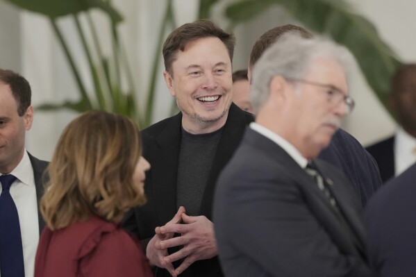 Elon Musk gestures as he arrives for a state dinner hosted by Qatar's Emir Sheikh Tamim bin Hamad Al Thani in honor of President Donald Trump at Lusail Palace in Doha, Qatar, Wednesday, May 14, 2025. (AP Photo/Alex Brandon)