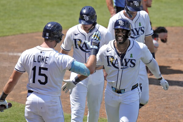 Tampa Bay Rays' Yandy DÌaz, right, celebrates with teammates, including Josh Lowe, left, after Diaz hit a three-run home run off Houston Astros Forrest Whitley during the eighth inning of a baseball game Wednesday, May 21, 2025, in Tampa, Fla. (AP Photo/Chris O'Meara)
