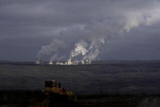 Smoke rises from chimneys of Turow power plant located by the Turow lignite coal mine near the town of Bogatynia, Poland, Saturday, Jan. 15, 2022. The Polish lignite mine is located near the Czech border and Czech authorities have said it negatively affects the environment and drains water from local villages. (AP Photo/Petr David Josek)