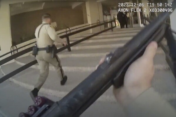 In this image made from body camera footage provided by the Las Vegas Metro Police Department, officers run into a building on the University of Nevada, Las Vegas campus, Wednesday, Dec. 6, 2023, in response to reports of a shooting. Police body camera footage from the shooting, which left three people dead and one wounded, was released Wednesday, Dec. 20. (Las Vegas Metro Police Department via AP)