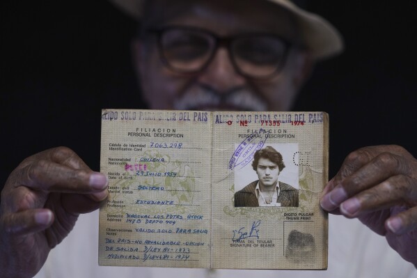 Chilean exile Sergio Naranjo shows his old, Chilean passport marked with the Spanish instruction: "Only valid to leave the country" in Mexico City, Thursday, Aug. 3, 2023. Naranjo, 69, was a member of Chile's Revolutionary Left Movement (MIR) and became a political exile on May 17, 1975 when he left a detention center and was expelled from Chile, landing in Mexico, following the military coup by Gen. Augusto Pinochet that ousted and killed Salvador Allende on Sept. 11, 1973. (AP Photo/Marco Ugarte)