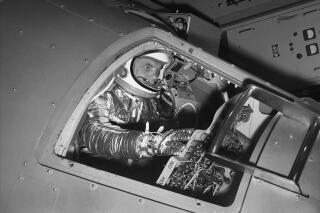 ARCHIVO  - En esta foto de archivo del 11 de enero de 1961, el astronauta John Glenn maneja los controles en una cápsula Mercury para demostrar cómo el 1er astronauta estadounidense recorrerá el espacio, en el centro de investigaciones de la NASA en Langley Field, Virginia. (AP Foto/File)