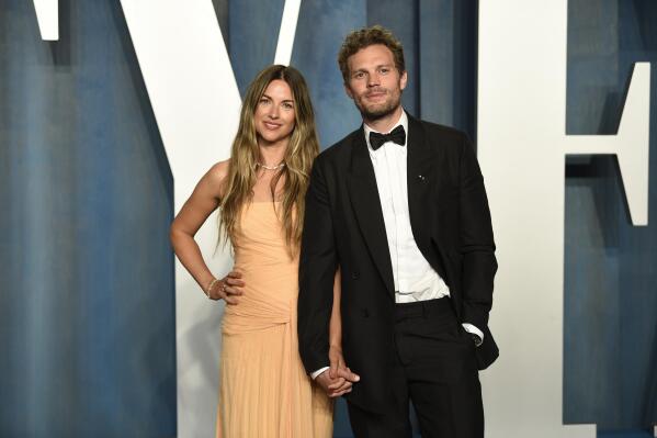 Amelia Warner, left, and Jamie Dornan arrives at the Vanity Fair Oscar Party on Sunday, March 27, 2022, at the Wallis Annenberg Center for the Performing Arts in Beverly Hills, Calif. (Photo by Evan Agostini/Invision/AP)