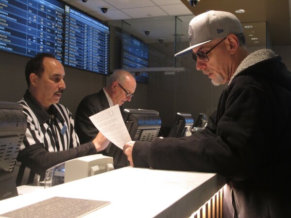 In this Jan. 29, 2020, photo, a gambler makes bets on the upcoming Super Bowl at Bally's casino in Atlantic City N.J. Gambling industry officials expect Sunday's Super Bowl to be among the most heavily wagered-on championship games ever. (AP Photo/Wayne Parry)