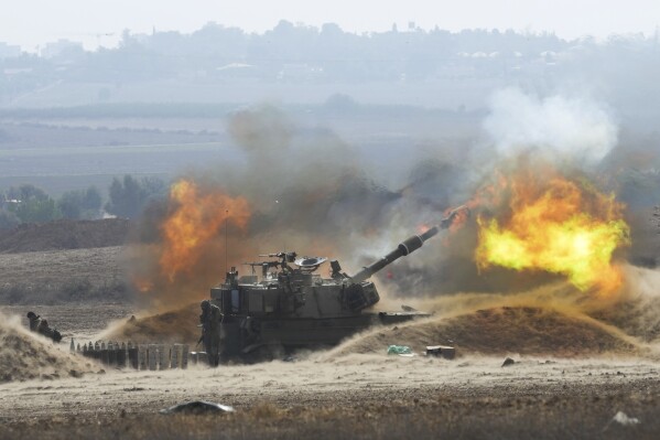 Flames erupt as an Israeli mobile artillery unit fires a shell from southern Israel towards the Gaza Strip, in a position a near the Israel Gaza border, Israel on Oct. 11, 2023. (APPhoto/Erik Marmor)