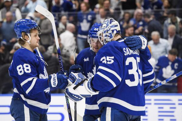 Toronto Maple Leafs right wing William Nylander (88) and defenseman Morgan Rielly (44) celebrate with goaltender Ilya Samsonov (35) after the team's win over the Chicago Blackhawks in an NHL hockey game Wednesday, Feb. 15, 2023, in Toronto. (Christopher Katsarov/The Canadian Press via AP)