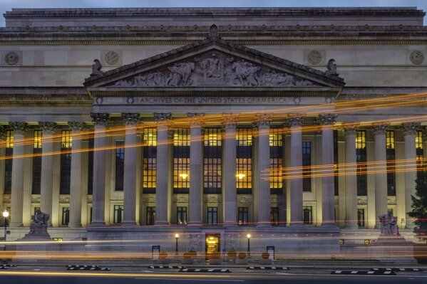 
              Traffic streaks past the U. S. National Archive headquarters building early in the morning, Tuesday, Oct. 24, 2017. President Donald Trump announced last week he intendeds to allow the National Archive to release additional classified documents on the assassination of President John F. Kenney. (AP Photos/J. David Ake)
            