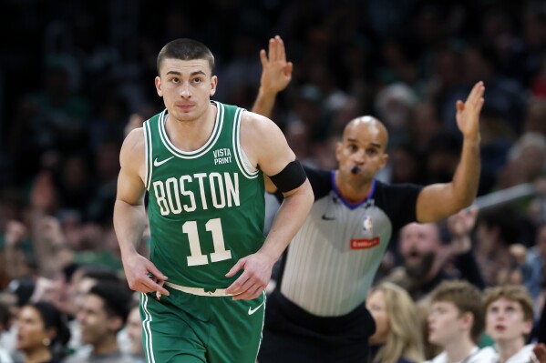 Boston Celtics' Payton Pritchard (11) heads up court after making a 3-pointer during the first half of an NBA basketball game against the Charlotte Hornets, Friday, April 12, 2024, in Boston. (AP Photo/Michael Dwyer)