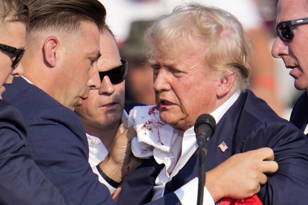 Republican presidential candidate former President Donald Trump is surrounded by U.S. Secret Service at a campaign event in Butler, Pa., on Saturday, July 13, 2024. (AP Photo/Gene J. Puskar)