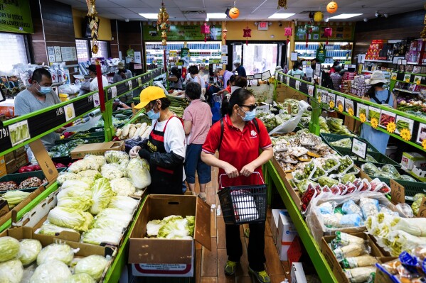 FILE - Customers shop for produce in the Chinatown neighborhood of Philadelphia, July 22, 2022. Asian Americans and Pacific Islanders in the United States are somewhat more optimistic than the overall adult population about their personal finances, but recent polling shows the outlook isn't quite as sunny when it comes to keeping up with household expenses or unexpected medical costs. (AP Photo/Matt Rourke, File)