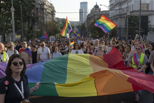 People hold a large Rainbow flag as they take part in a Pride march in Belgrade, Serbia, Saturday, Sept. 9, 2023. Hundreds of Pride activists gathered in the Serbian capital Saturday amid heavy police presence and anti-gay messages sent by the country's conservative leadership and far rights groups. (AP Photo/Marko Drobnjakovic)