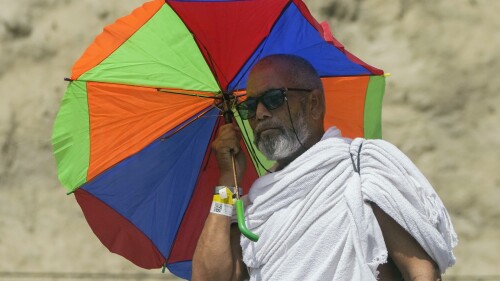 Un peregrino musulmán se protege del sol con un paraguas mientras participa en uno de los rituales de la peregrinación anual del haj, en Mina, cerca de la ciudad santa de La Meca, Arabia Saudí, el 28 de junio de 2023. (AP Foto/Amr Nabil)