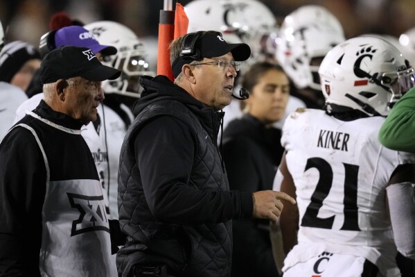 Cincinnati head coach Scott Satterfield watches from the bench during the first half of an NCAA college football game against Iowa State, Saturday, Nov. 16, 2024, in Ames, Iowa. (AP Photo/Charlie Neibergall)