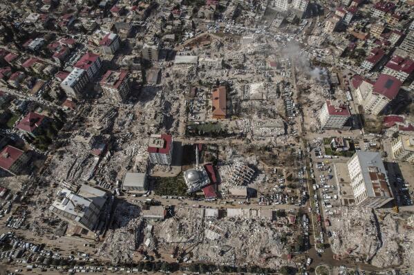 Aerial photo showing the destruction in Kahramanmaras city center, southern Turkey, Thursday, Feb. 9, 2023. Thousands who lost their homes in a catastrophic earthquake huddled around campfires and clamored for food and water in the bitter cold, three days after the temblor and series of aftershocks hit Turkey and Syria. (IHA via AP)