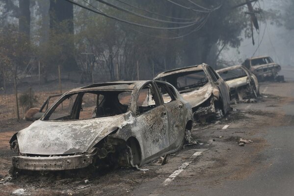 
              FILE - This Nov. 9, 2018, file photo the burned out hulks of cars abandoned by their drivers sit along a road in Paradise, Calif. The scale of disaster in the Camp Fire was unprecedented, but the scene of people fleeing wildfire was familiar, repeated numerous times over the past three years up and down California from Redding and Paradise to Santa Rosa, Ventura and Malibu. (AP Photo/Rich Pedroncelli, File)
            