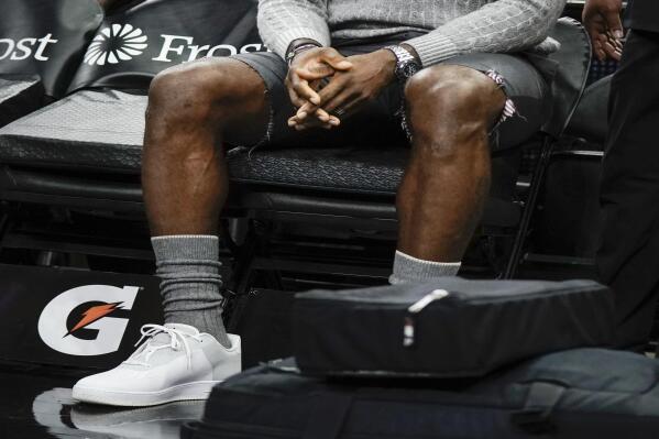 Los Angeles Lakers forward LeBron James sits on the bench during the first half of an NBA basketball game against the San Antonio Spurs on Tuesday, Oct. 26, 2021, in San Antonio, Texas. Los Angeles won 125-121 in overtime. (AP Photo/Darren Abate)