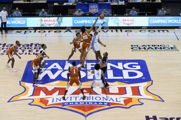 FILE - Texas forward Jericho Sims (20) and North Carolina forward Armando Bacot (5) tip off for the start of an NCAA college basketball game for the championship of the Maui Invitational, Wednesday, Dec. 2, 2020, in Asheville, N.C. The Maui Invitational will be played in Honolulu this year because of the wildfire that devastated Lahaina where the tournament usually is played. (AP Photo/Kathy Kmonicek, File)
