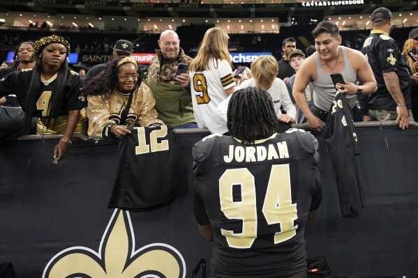 New Orleans Saints defensive end Cameron Jordan (94) signs autographs after an NFL football game against the Las Vegas Raiders, Sunday, Dec. 29, 2024, in New Orleans. (AP Photo/Gerald Herbert)