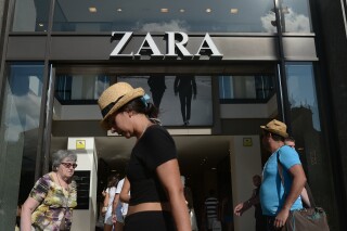 FILE - People walk past a Zara store in Barcelona, Spain, Aug. 27, 2014. The Spanish fashion brand Zara has pulled advertising images that to some appeared to reference Israel’s war against Hamas in Gaza. (AP Photo/Manu Fernandez, File)