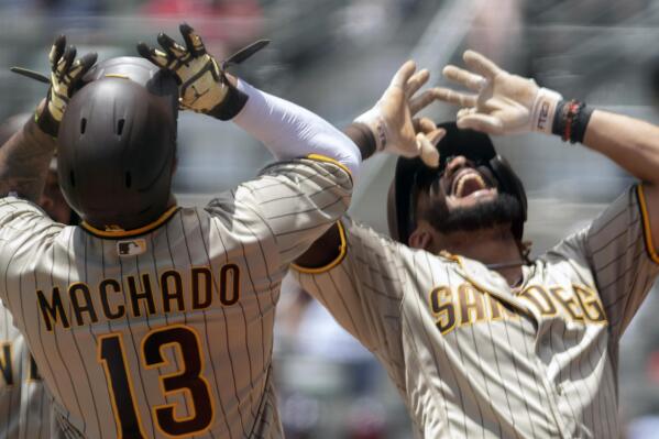 San Diego Padres third baseman Manny Machado (13) and Padres shortstop Fernando Tatis Jr. celebrate a two-run home run by Tatis against the Atlanta Braves in the fifth inning in the first game of a baseball doubleheader Wednesday, July 21, 2021, in Atlanta. (AP Photo/Hakim Wright Sr.)