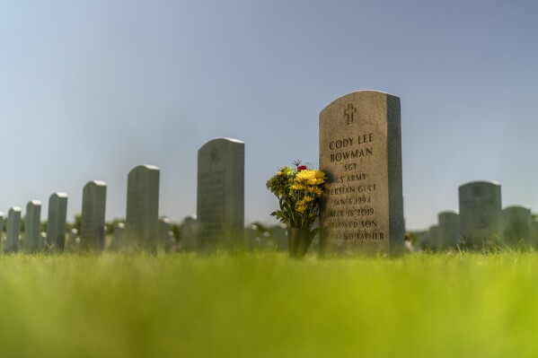 The tombstone of Army Sgt. Cody Bowman stands at the Dallas-Fort Worth National Cemetery, Sunday, June 11, 2023, in Dallas. For decades, discussions of suicide prevention skirted fraught questions about firearms; the Army has punted implementing measures that might be controversial. But a growing movement has taken hold, among researchers, the Veterans Administration, ordinary people like Bowman's mother, Barbie Rohde, if this country wants to get serious about addressing an epidemic of suicide, it must find a way to honor veterans and active-duty service members, respect their rights to own a gun, but keep it out of their hands on their darkest days. (AP Photo/David Goldman)