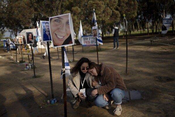 Israeli women May, left, and Lilach, right, comfort each other as they visit the marker for Tifret Lapidot, their friend who was killed on Oct. 7, 2023 at the Nova music festival by Hamas militants during a cross-border attack, as they visit the site in Re'im, southern Israel near the Gaza border, Wednesday, Jan. 24, 2024. In late November, the sides agreed to one-week cease-fire. Hamas released over 100 of the 250 hostages it was holding, mostly women and children, while Israel freed 240 Palestinian prisoners. The sides blamed each other for the failure to extend the deal, and fighting has worsened since then. (AP Photo/Maya Alleruzzo)