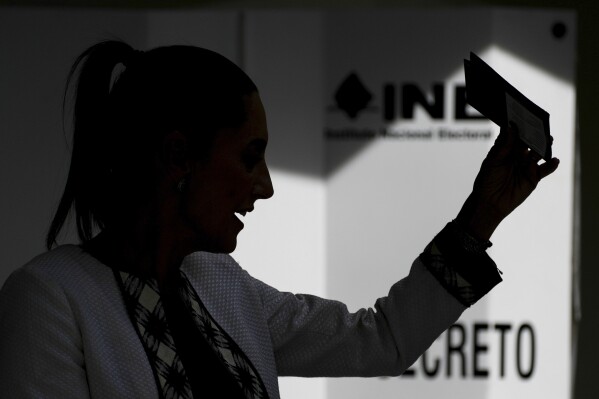 Ruling party presidential candidate Claudia Sheinbaum shows her ballot before voting, during general elections in Mexico City, Sunday, June 2, 2024. (AP Photo/Marco Ugarte)