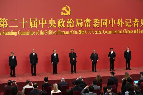 New members of the Politburo Standing Committee, from left, Li Xi, Cai Qi, Zhao Leji, President Xi Jinping, Li Qiang, Wang Huning, and Ding Xuexiang are introduced at the Great Hall of the People in Beijing, Sunday, Oct. 23, 2022. (AP Photo/Ng Han Guan)