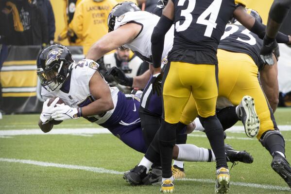 Baltimore Ravens running back J.K. Dobbins dives across the goal line for a touchdown during the first half of an NFL football game against the Pittsburgh Steelers in Pittsburgh, Sunday, Dec. 11, 2022. (AP Photo/Fred Vuich)