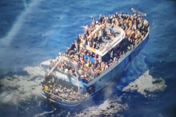 FILE - This undated handout image provided by Greece's coast guard on June 14, 2023, shows scores of people on a battered fishing boat that later capsized and sank off southern Greece. Survivors of a deadly migrant shipwreck in southern Greece three months ago are suing authorities for failing to intervene to rescue passengers before their vessel capsized in international waters, their lawyers said Thursday, Sept. 14, 2023. (Hellenic Coast Guard via AP, File)