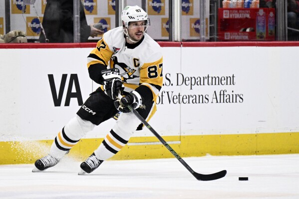 Pittsburgh Penguins center Sidney Crosby (87) skates with the puck during the first period of the team's NHL hockey game against the Washington Capitals, Thursday, April 4, 2024, in Washington. (AP Photo/Nick Wass)
