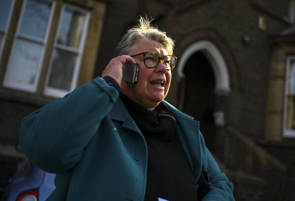 The Rev. April Keech, an Anglican priest, who organizes food deliveries to old and vulnerable people, makes a phone call in London, Saturday, March 28, 2020. Keech and her team of volunteers have spent the past two weeks buying groceries, filling prescriptions and making deliveries to residents in east London who are at risk of serious illness or death from the COVID-19 disease. The new coronavirus causes mild or moderate symptoms for most people, but for some, especially older adults and people with existing health problems, it can cause more severe illness or death. (AP Photo/Alberto Pezzali)